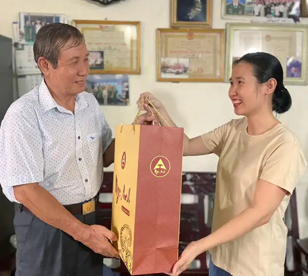 Tác Dụng Của Nấm Lim Xanh 10 Hình cô gái trao hộp quà nấm lim xanh cho khách hàng, thể hiện tình cảm tích cực